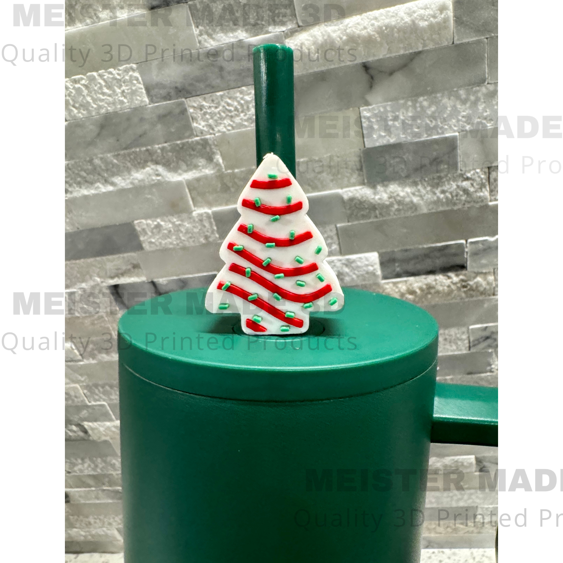 Green tumbler with a Little Debbie Christmas tree-themed straw buddy on a gray stone background