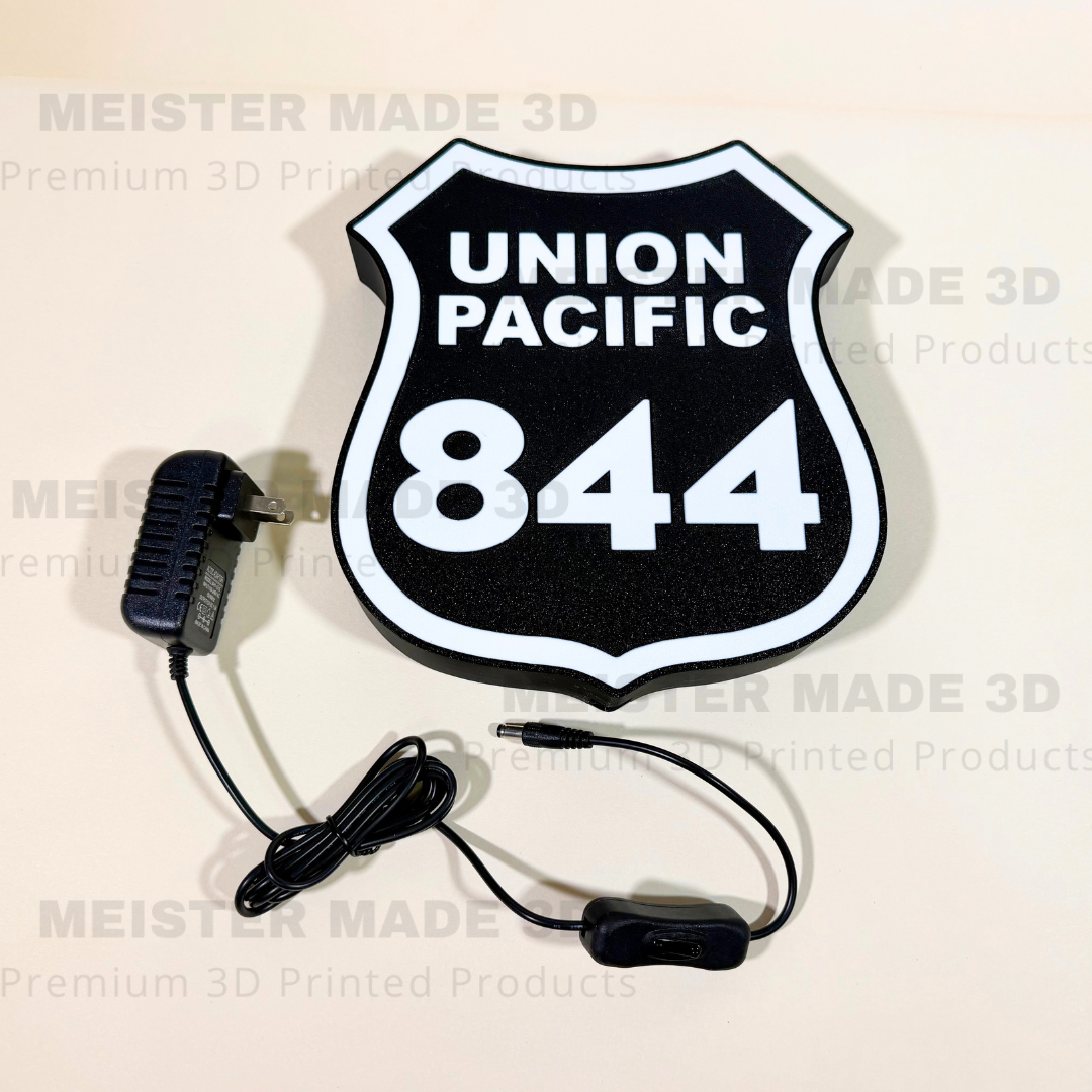 Union Pacific 844 illuminated railroad sign with included power adapter and inline switch, featuring a black and white locomotive shield design for train room decor.