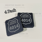 Two laser engraved Union Pacific 4014 shields on black slate coasters on  a tan background