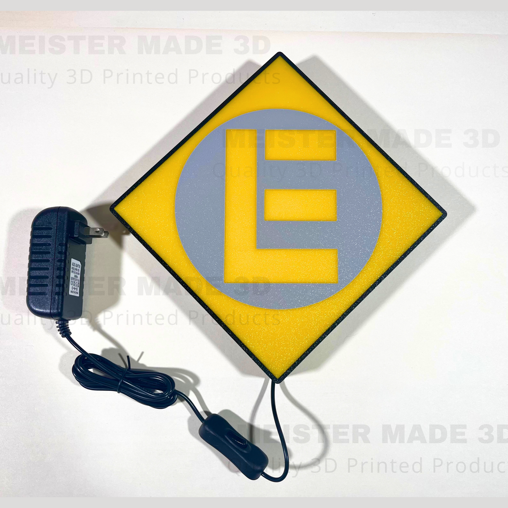 Yellow square sign with a gray circle and letter 'E', connected to a power adapter on a white background.