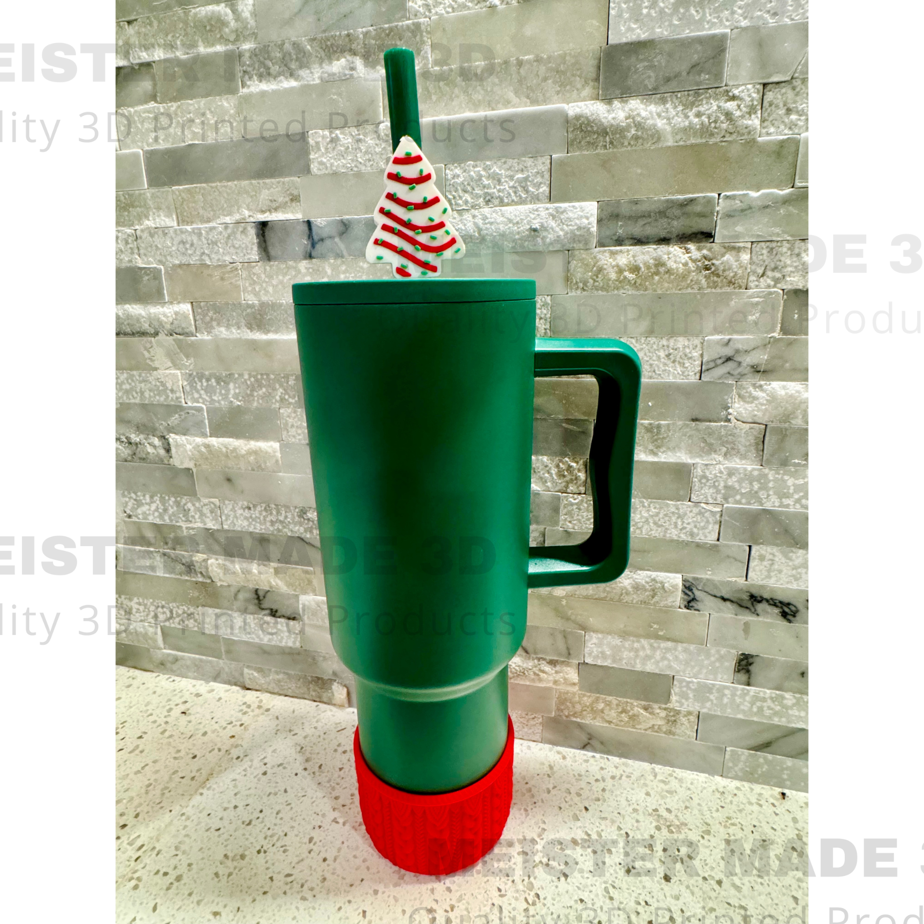 Green tumbler with a Little Debbie Christmas tree-themed straw buddy on a gray stone background