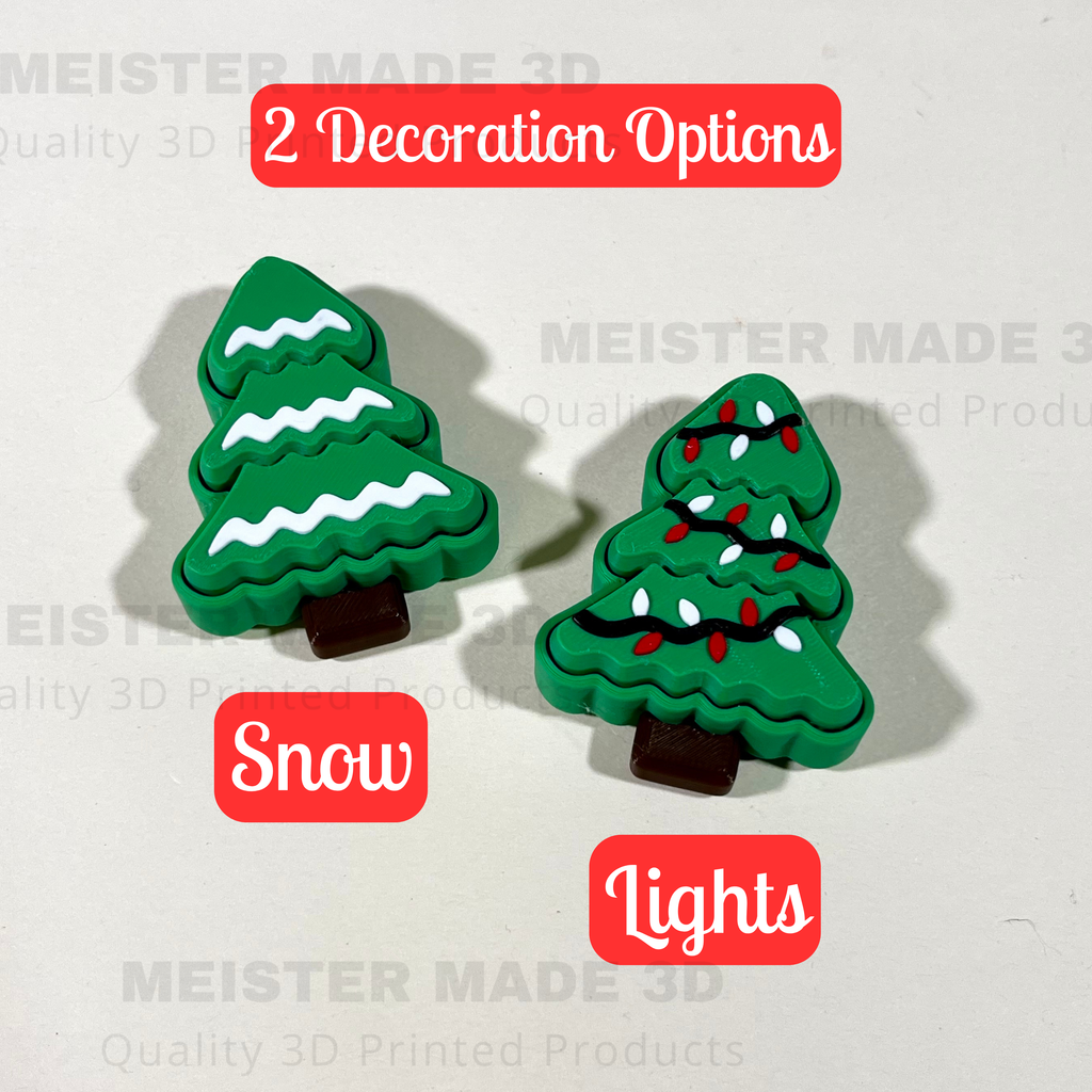 Two green Christmas tree decorations with snow and lights on a white background.