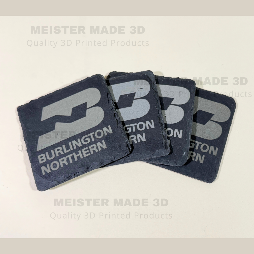 Four laser engraved Burlington Northern slate coasters displayed in a fan arrangement, showcasing natural stone edges and detailed BN railroad logo engraving.