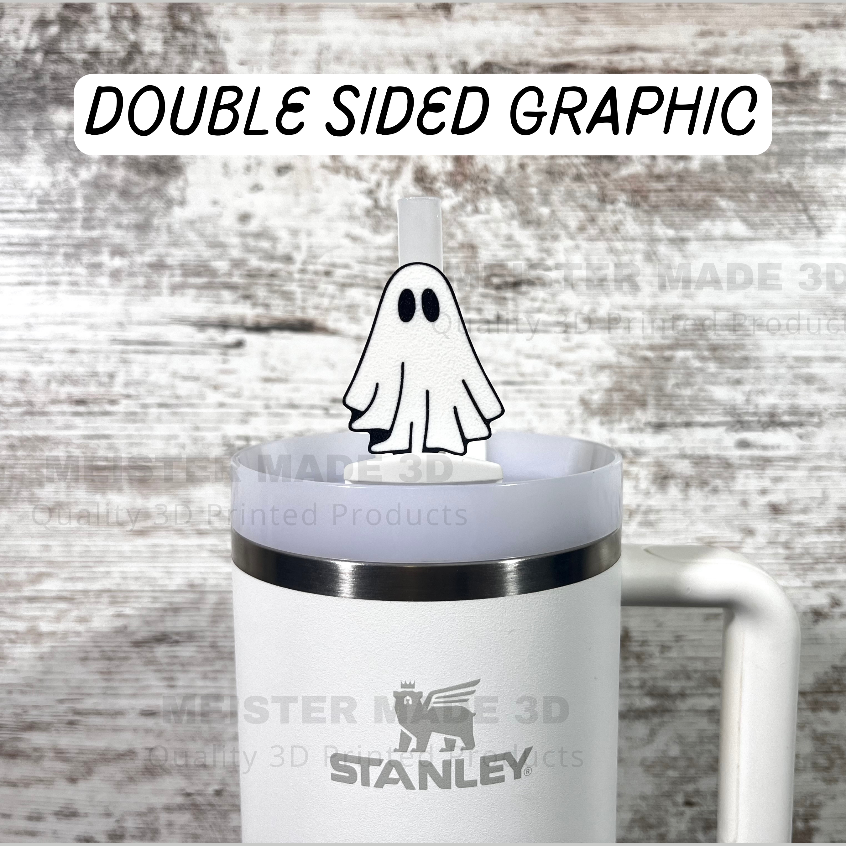 White Stanley mug with a white ghost-themed straw buddy on a wooden surface. Text saying double sided graphic.