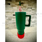 Green tumbler with a Little Debbie Christmas tree-themed straw buddy on a gray stone background