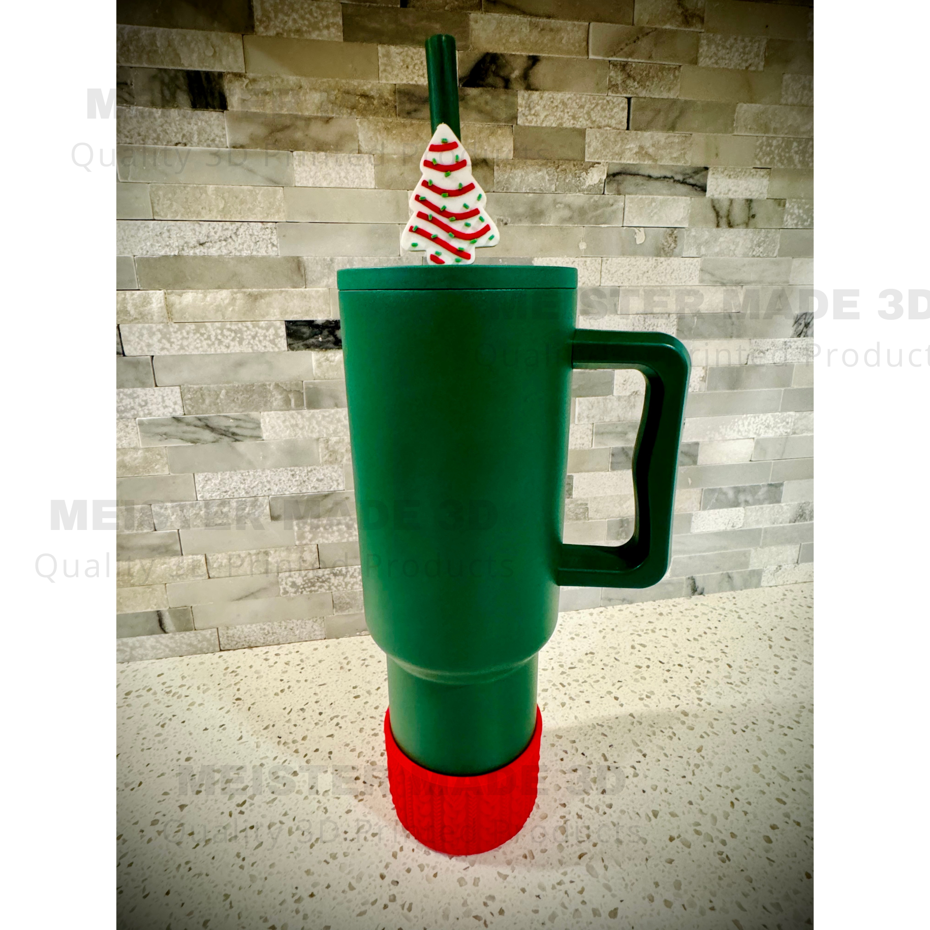 Green tumbler with a Little Debbie Christmas tree-themed straw buddy on a gray stone background