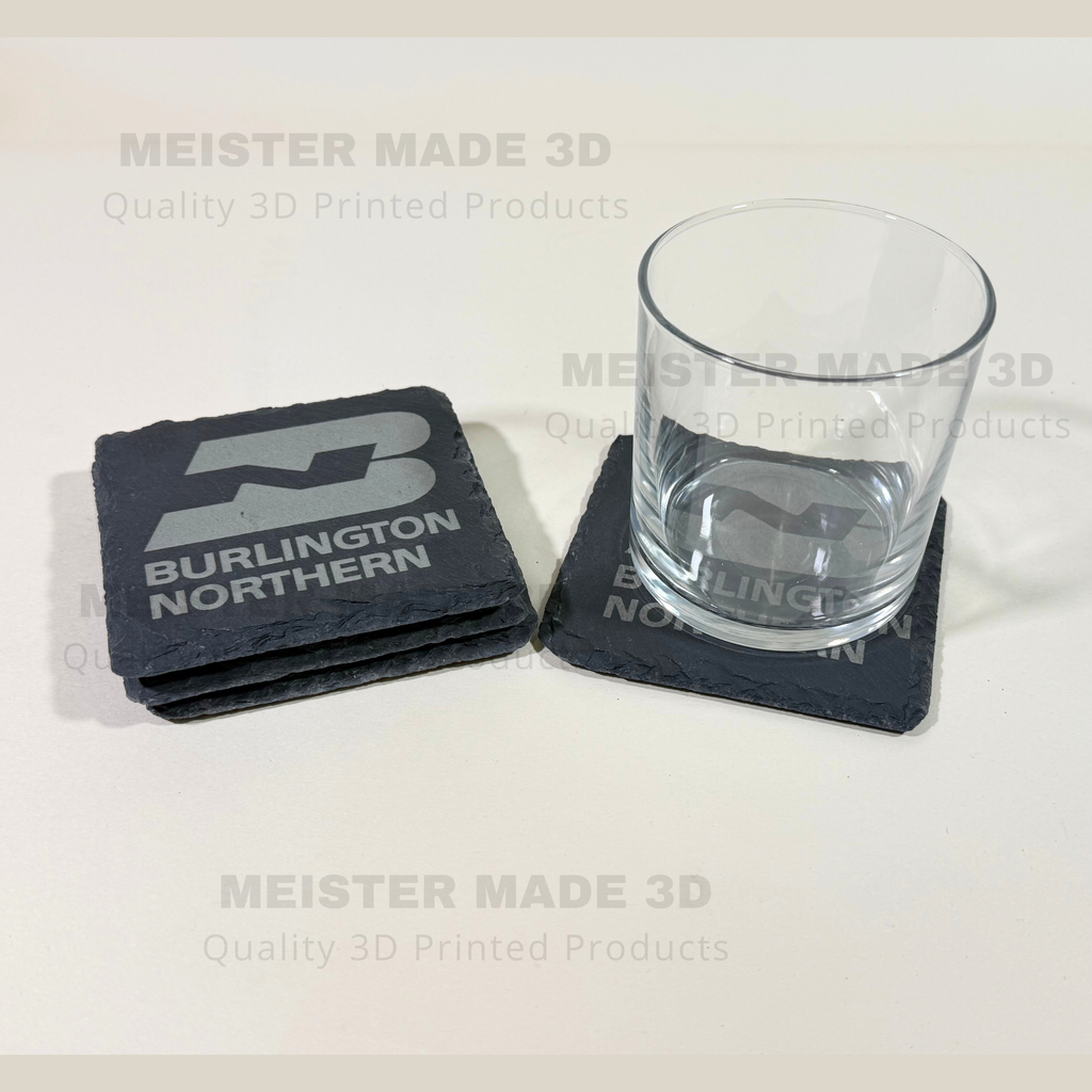 Laser engraved Burlington Northern slate coaster protecting a glass, demonstrating the coaster's size, durability, and railroad-themed design for home or office use.