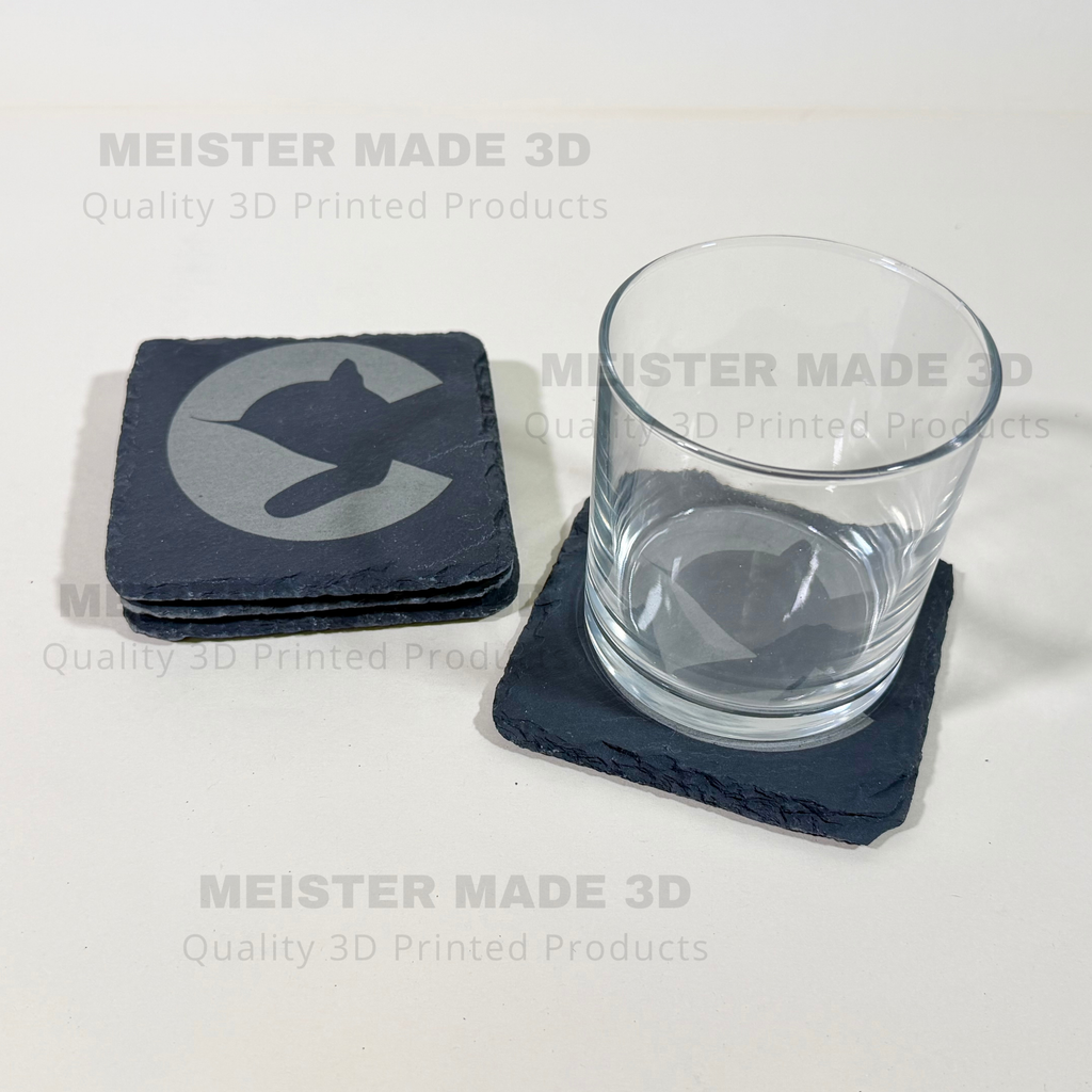 Four square slate coasters, each engraved with a Chessie System Logo. A glass sits on one of the coasters showing the functionality. The image includes repeated 'MEISTER MADE 3D Quality 3D Printed Products' watermarks on a plain light background.