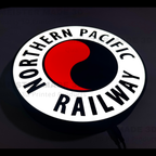 Illuminated Northern Pacific Railway logo with red and black design on a dark background
