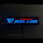 Montana Rail Link LED sign illuminated in dark setting with glowing blue and red lettering for railroad room or office decor.