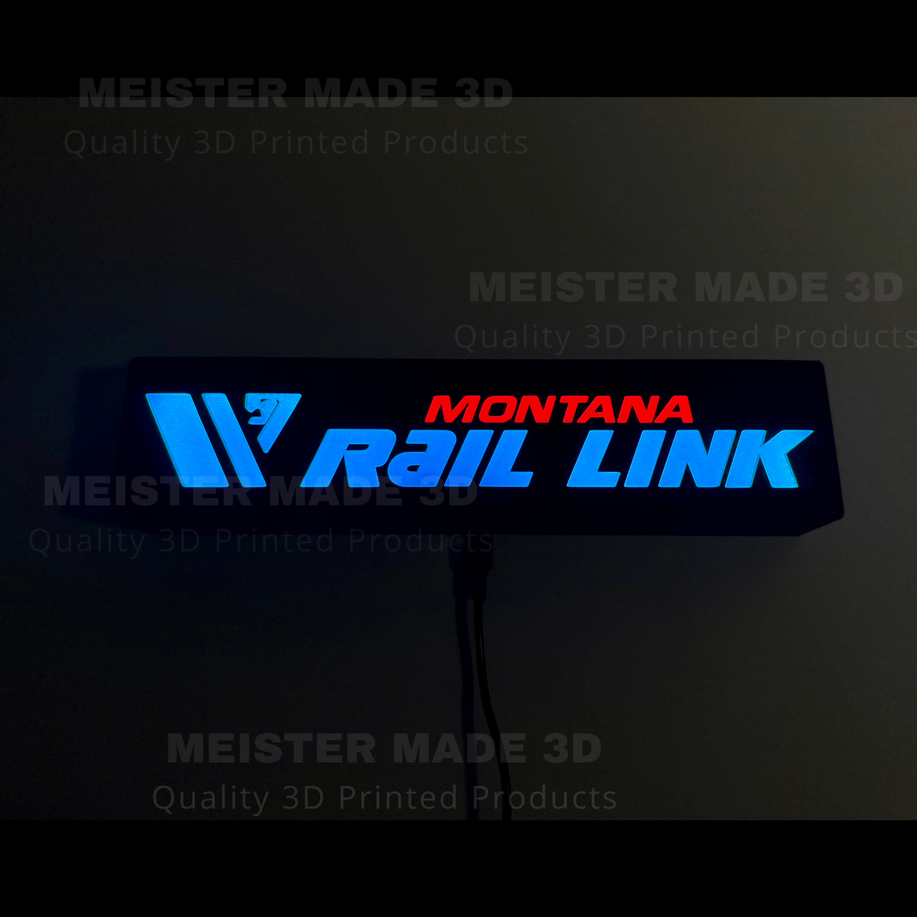 Montana Rail Link LED sign illuminated in dark setting with glowing blue and red lettering for railroad room or office decor.