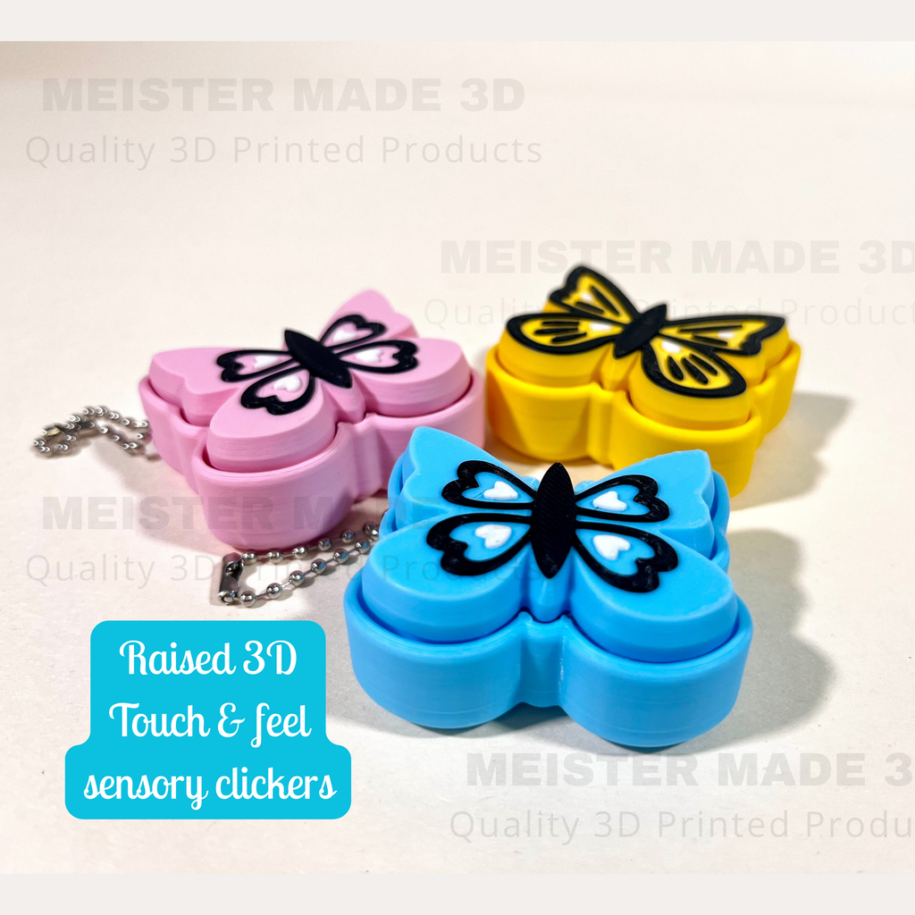 Three butterfly-shaped sensory clickers in pink, yellow, and blue on a light background with 'MEISTER MADE 3D' branding.