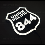 Angled illuminated Union Pacific 844 train sign displaying the classic railroad shield design with bright white LED lighting, ideal for railroad enthusiasts and train room decor.